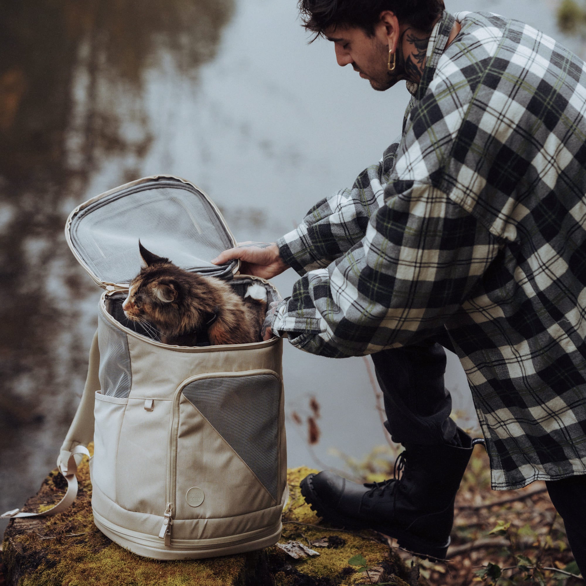 Zaino per gatti HOP-ON in sabbia, uomo che apre la borsa durante una gita nella natura, gatto tigrato che guarda fuori