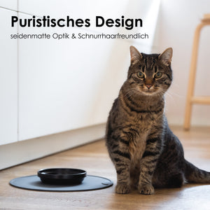 Bol en porcelaine BOWL en noir – design puriste à la surface satinée mate, un chat en arrière-plan.
