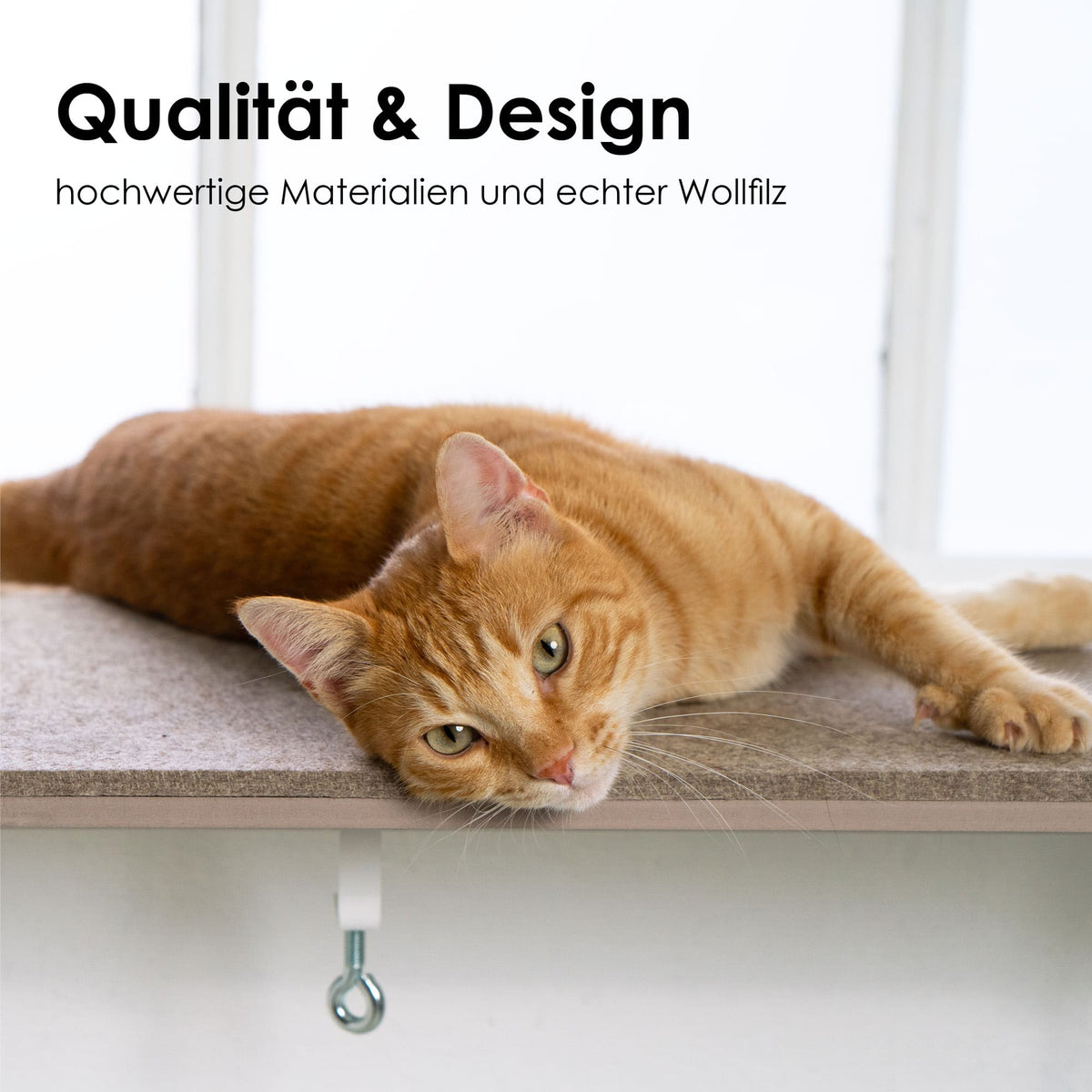 VIEW Fensterbankliege – hochwertige Wollfilzauflage, orangefarbene Katze liegt entspannt am Fenster.