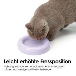 Bol pour chat DROP en lilas mat – position de repas légèrement surélevée, un chat buvant dans le bol.
