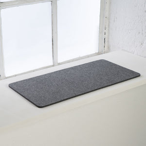 Anthrazitfarbene FELTY Fensterbrettauflage aus Wollfilz auf weißer Fensterbank