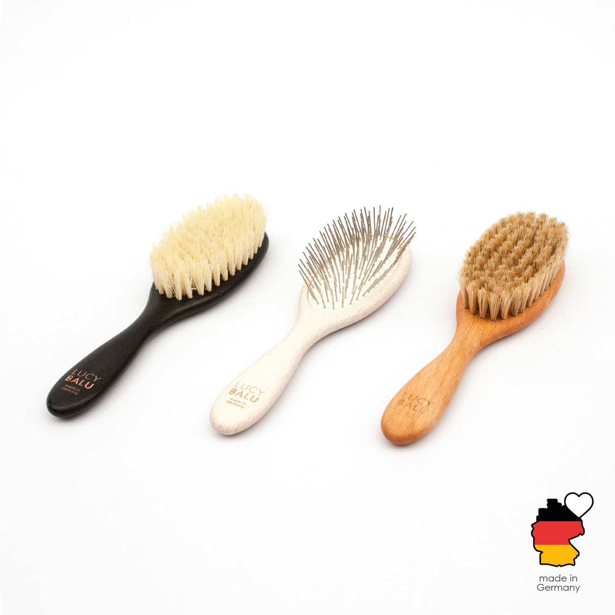 Trois brosses pour chat FIGARO en noir, blanc et naturel côte à côte, made in Germany