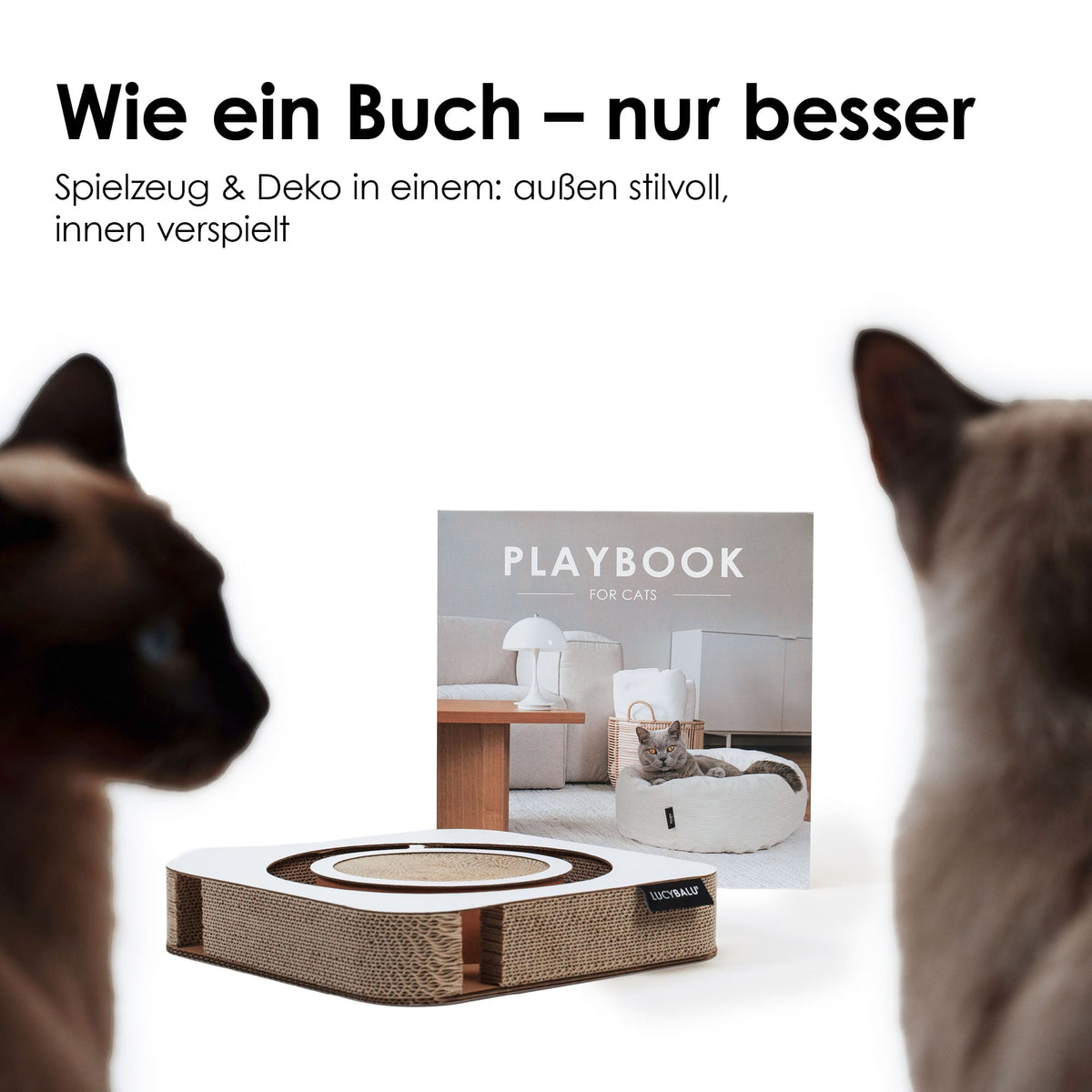 Zwei Katzen spielen auf weißem PLAYBOOK Kratzbrett aus Wellpappe mit rundem Kratzbereich und integriertem Ball