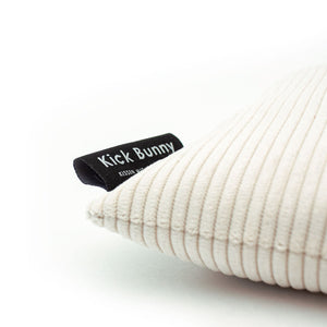 Seitliche Detailansicht eines cremefarbenen Cord KICK BUNNY Kissens mit eingenähtem Label