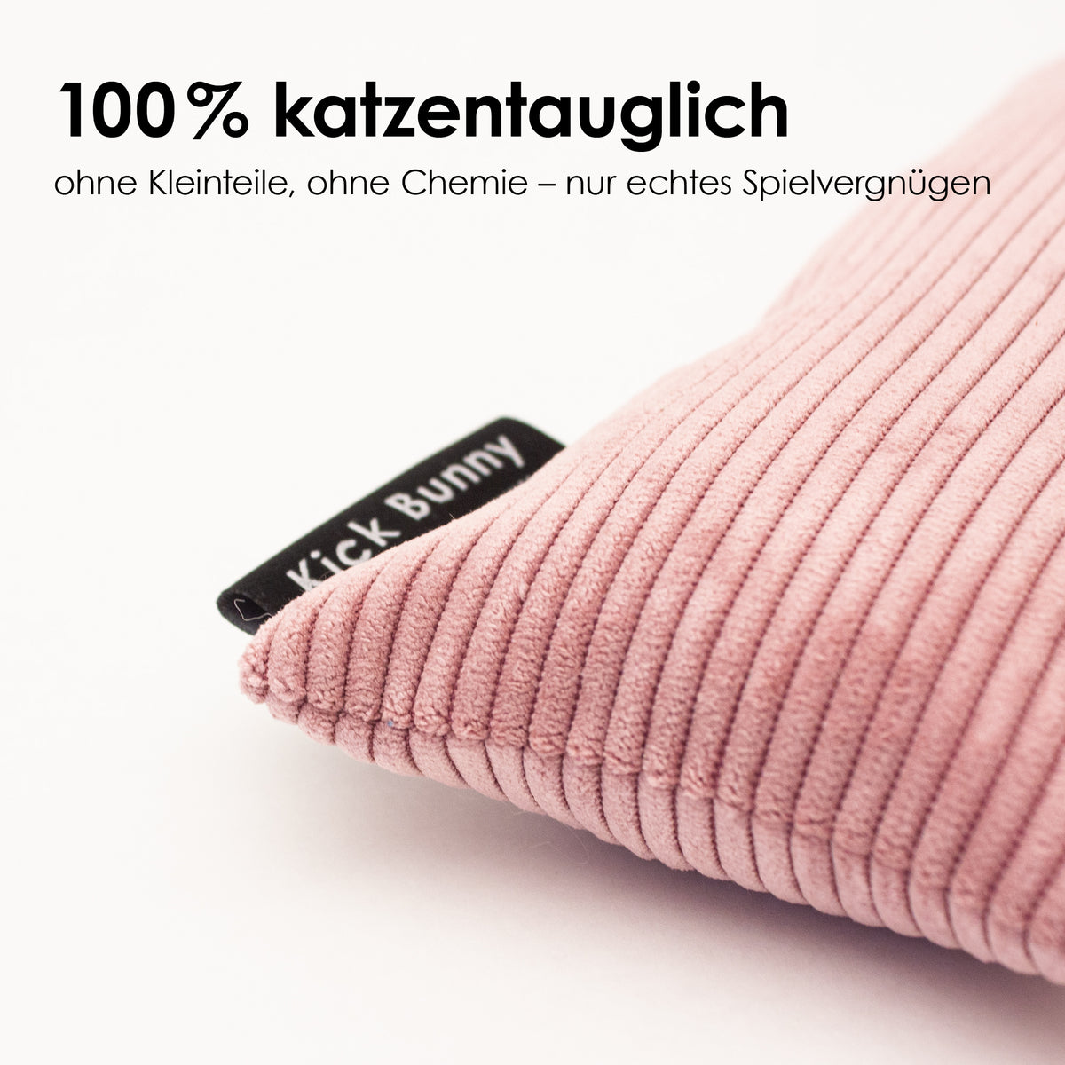 Detailaufnahme eines rosa Cord KICK BUNNY Kissens mit strukturierter Oberfläche und schwarzem Label