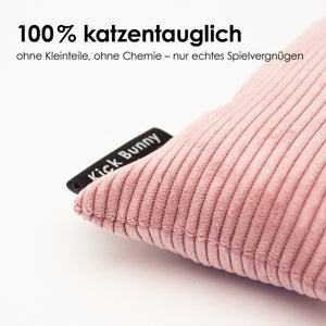 Detailaufnahme eines rosa Cord KICK BUNNY Kissens mit strukturierter Oberfläche und schwarzem Label