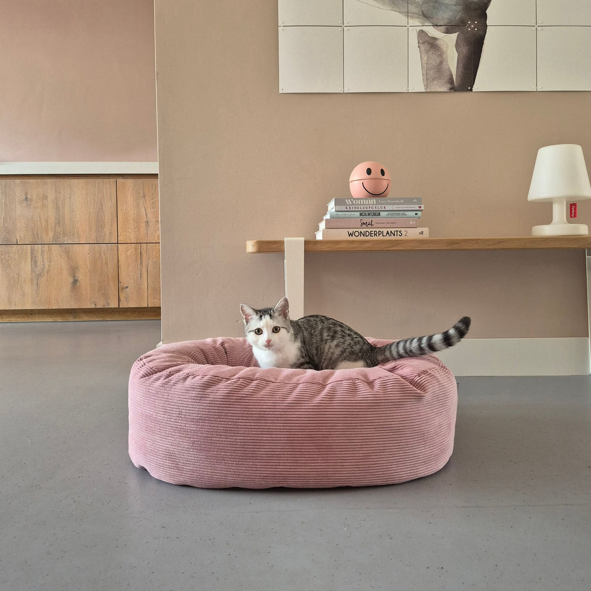 Getigerte Katze liegt in rosa DINGHY Katzenbett Hello Kitty Edition aus Cord im Wohnzimmer