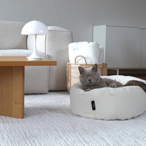 Cuccia per gatti DINGHY in bianco crema, gatto grigio sdraiato rilassato in soggiorno