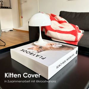 LucyBalu PLAYBOOK mit Kitten Cover als dekoratives Katzenspielzeug im Coffee Table Book Design auf einem Wohnzimmertisch