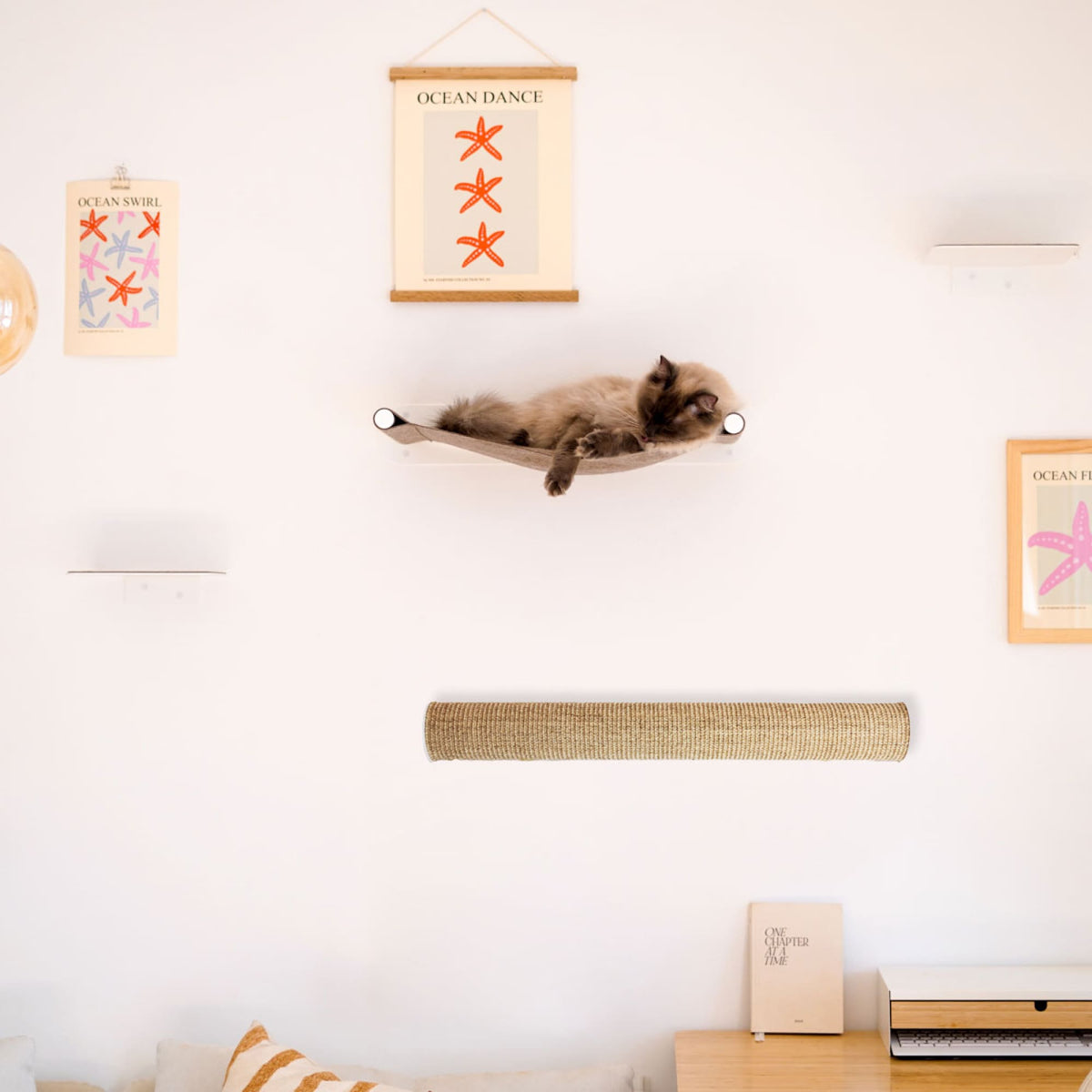 Katze liegt in SWING Hängematte Weiß über horizontal montierter CATWALK Kratzsäule an der Wand