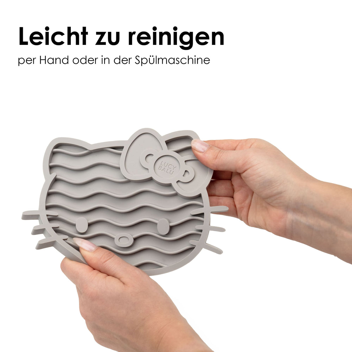 Hände halten ZENCAT Schleckmatte - Hello Kitty Edition in Taupe zum Reinigen