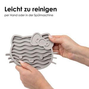 Hände halten ZENCAT Schleckmatte - Hello Kitty Edition in Taupe zum Reinigen