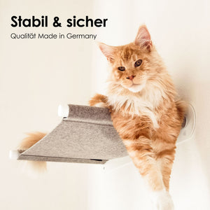 Grande gatto arancione sdraiato di lato sull'amaca da parete SWING con supporti bianchi – stabile e sicura, made in Germany.