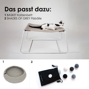 Katze liegt auf der grauen FLOAT Hängematte, passend dazu BASKET Katzenbett und SHADES OF GREY Filzbälle