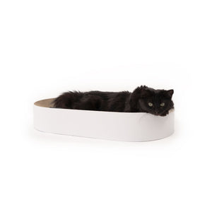 Lit à griffer SCRATCHBED en blanc, un chat noir à poil long allongé détendu à l'intérieur et regardant l'objectif
