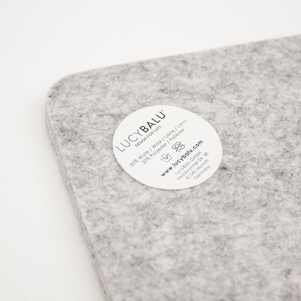 Nahaufnahme der grauen FELTY Filzauflage mit LucyBalu Materialetikett