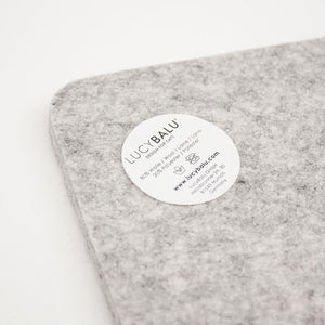 Nahaufnahme der grauen FELTY Filzauflage mit LucyBalu Materialetikett